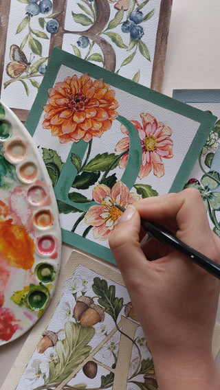 Hand painting floral designs on cards with a watercolor palette.