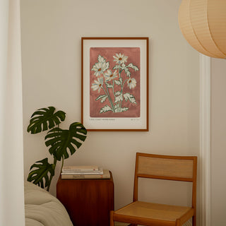Our anemone blanda art print with a hand painted dusty rose pink background and light lilac flower heads. Small text reading floral studies; anemone blanda NO.5 styled in a dark wood frame in a bedroom