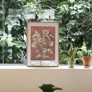 Our anemone blanda art print with a hand painted dusty rose pink background and light lilac flower heads. Small text reading floral studies; anemone blanda NO. 5 styled against greenery and plants