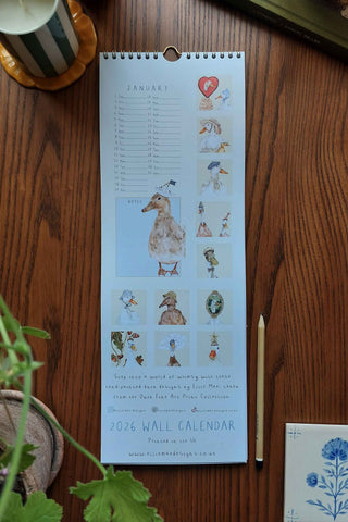 Wall calendar with illustrations on a wooden surface