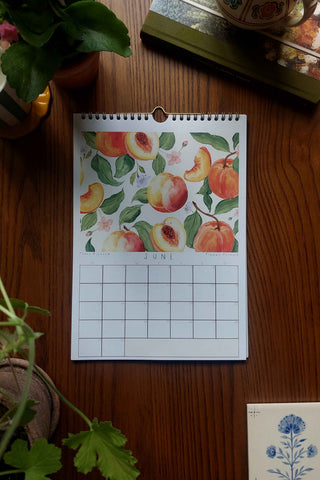 Calendar with peach design on a wooden surface