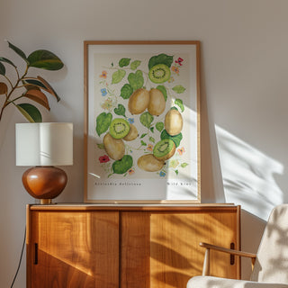 kiwi fruit botanical vintage style art print styled in thin oak frame on wooden unit with mid century lamp and plant 