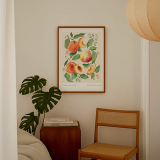 peach art print styled in bedroom by chair and monstera plant 