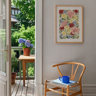 petunia blooms art print styled on blank wall in a2 by the garden with flower pots, books and a wooden chair