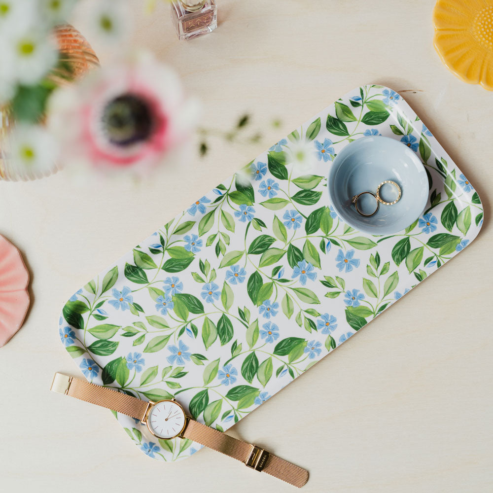 floral blue tray being used as a vanity display tray, holding watch, and trinket dish of jewellery